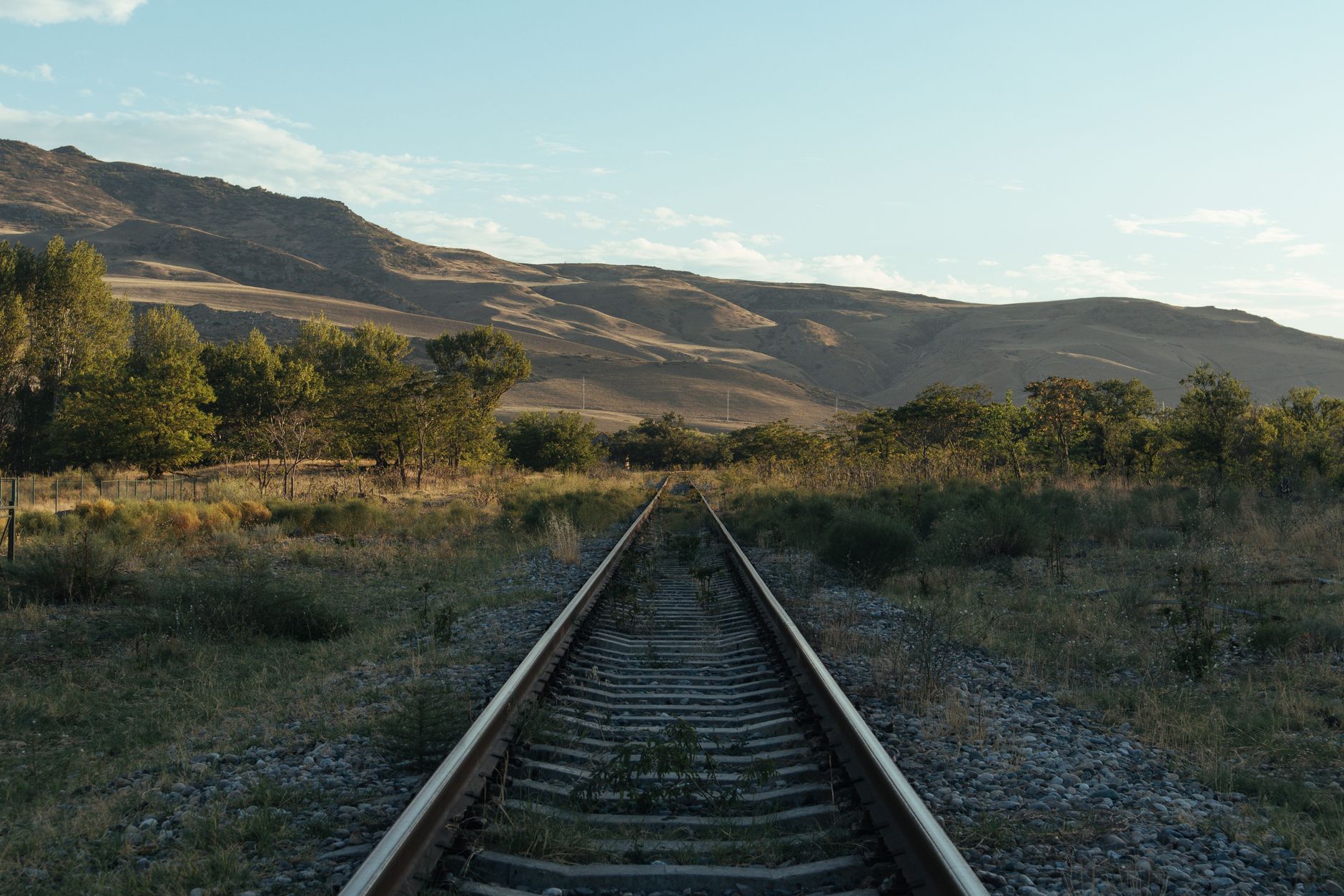 View of an abandoned railway track leading through scenic mountain terrain