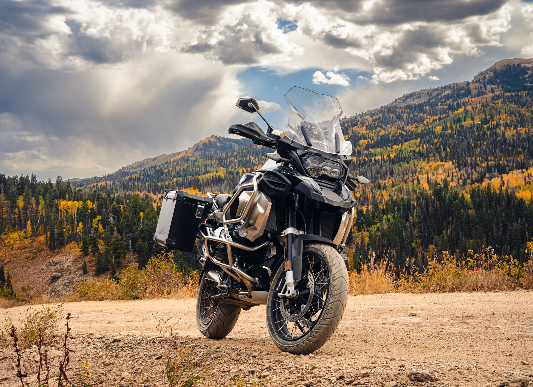 Powerful adventure motorcycle parked on a mountain road with autumn foliage