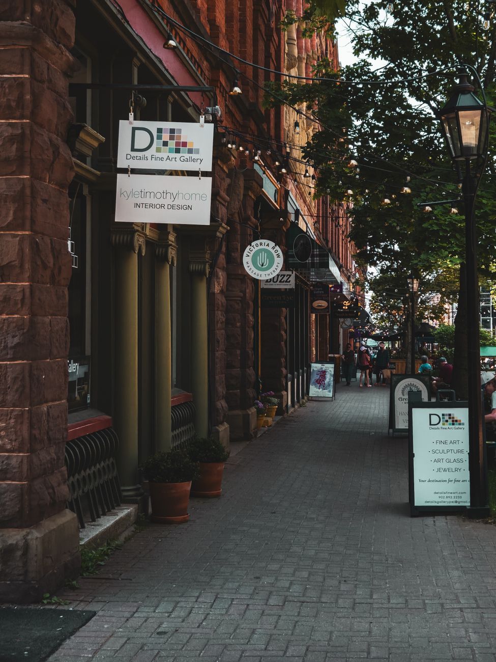 A quaint street with art gallery signs and brick buildings