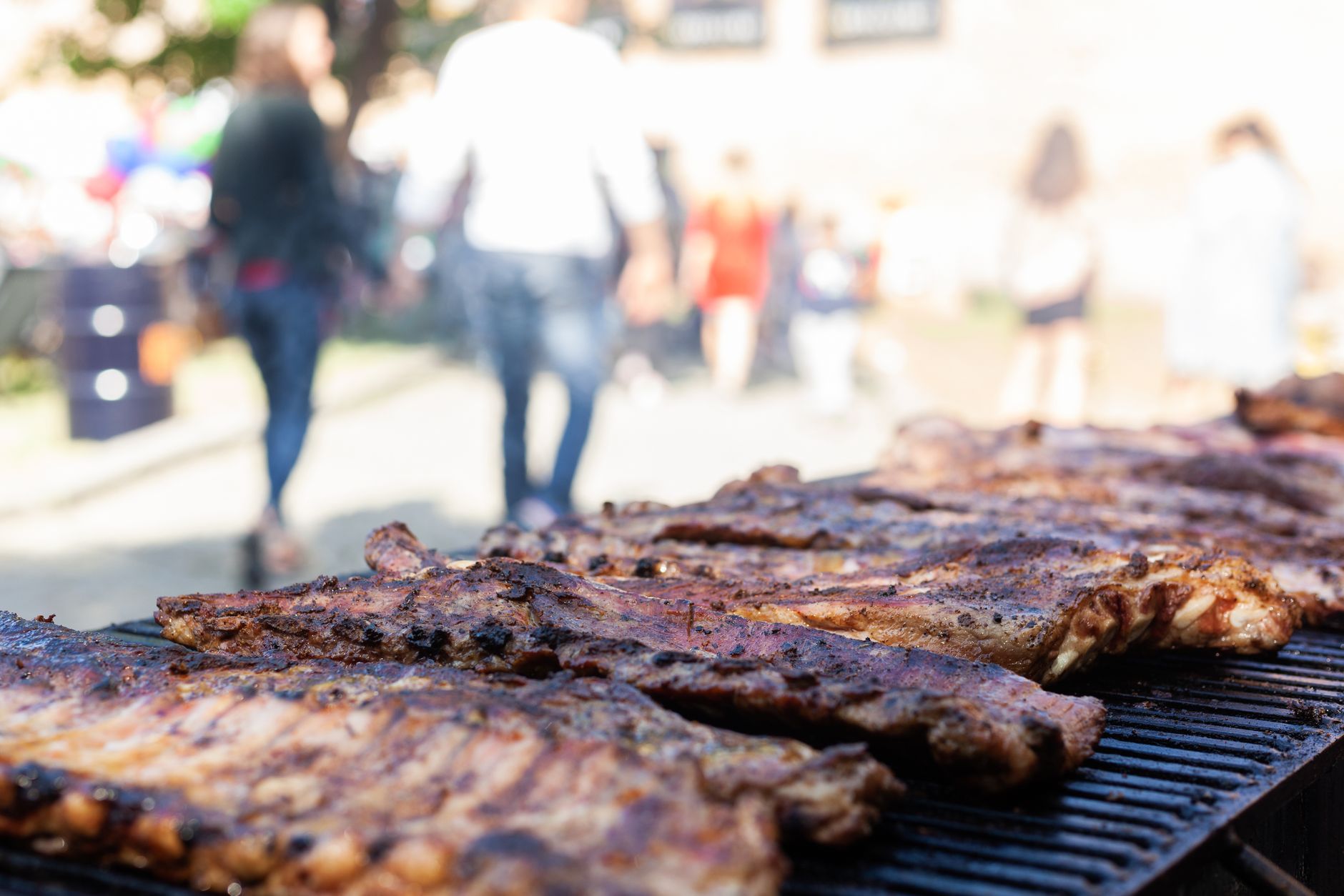 A rack of baby back ribs cooking slowly on the grill