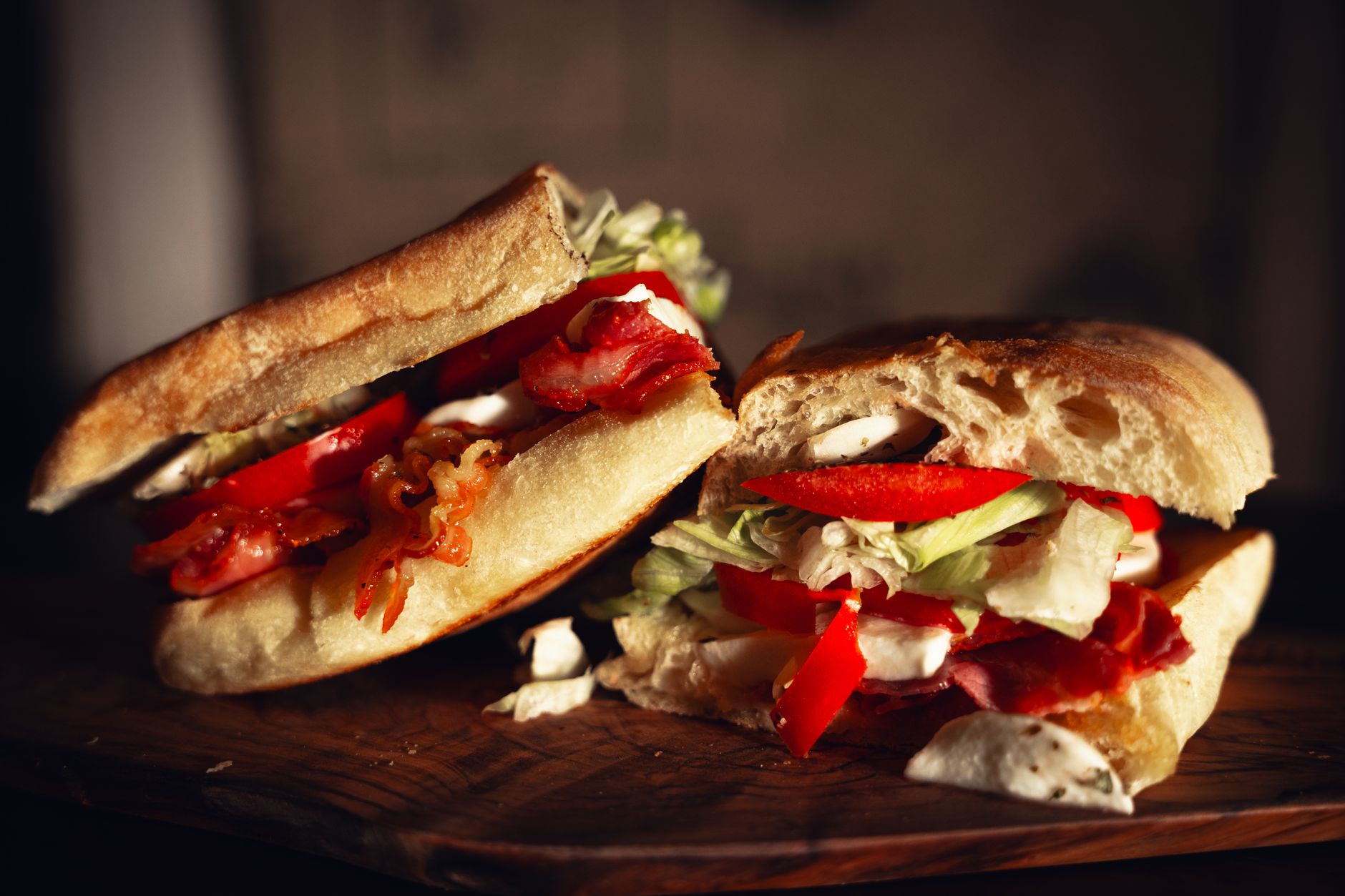 Close-up of a mouthwatering bacon and vegetable sandwich on a rustic board
