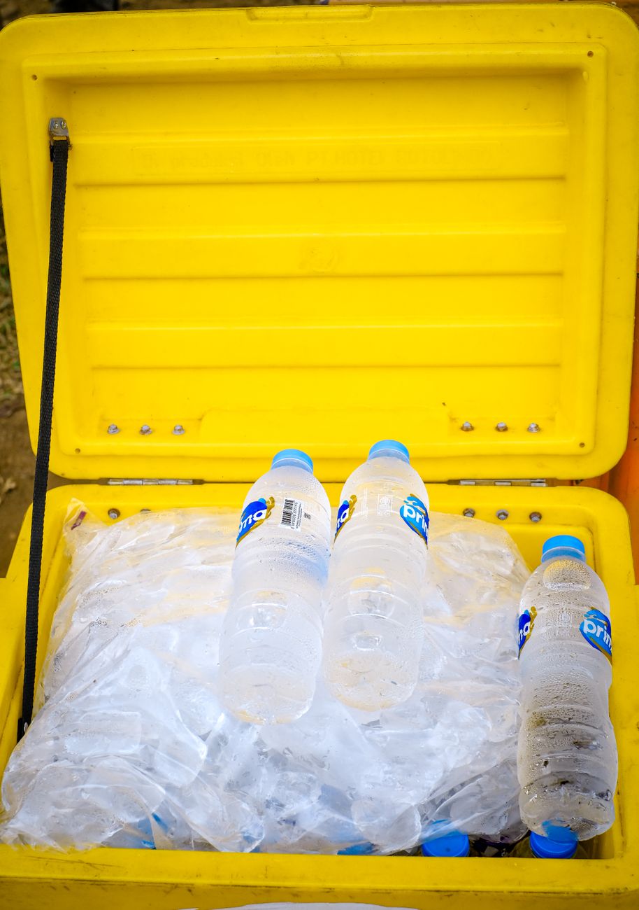 Bottled water in a yellow cooler with ice, perfect for outdoor summer trips