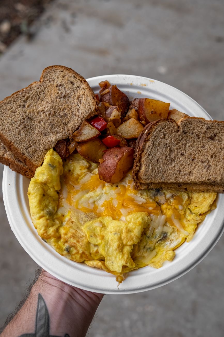 A hearty breakfast plate with scrambled eggs, toast, and potatoes