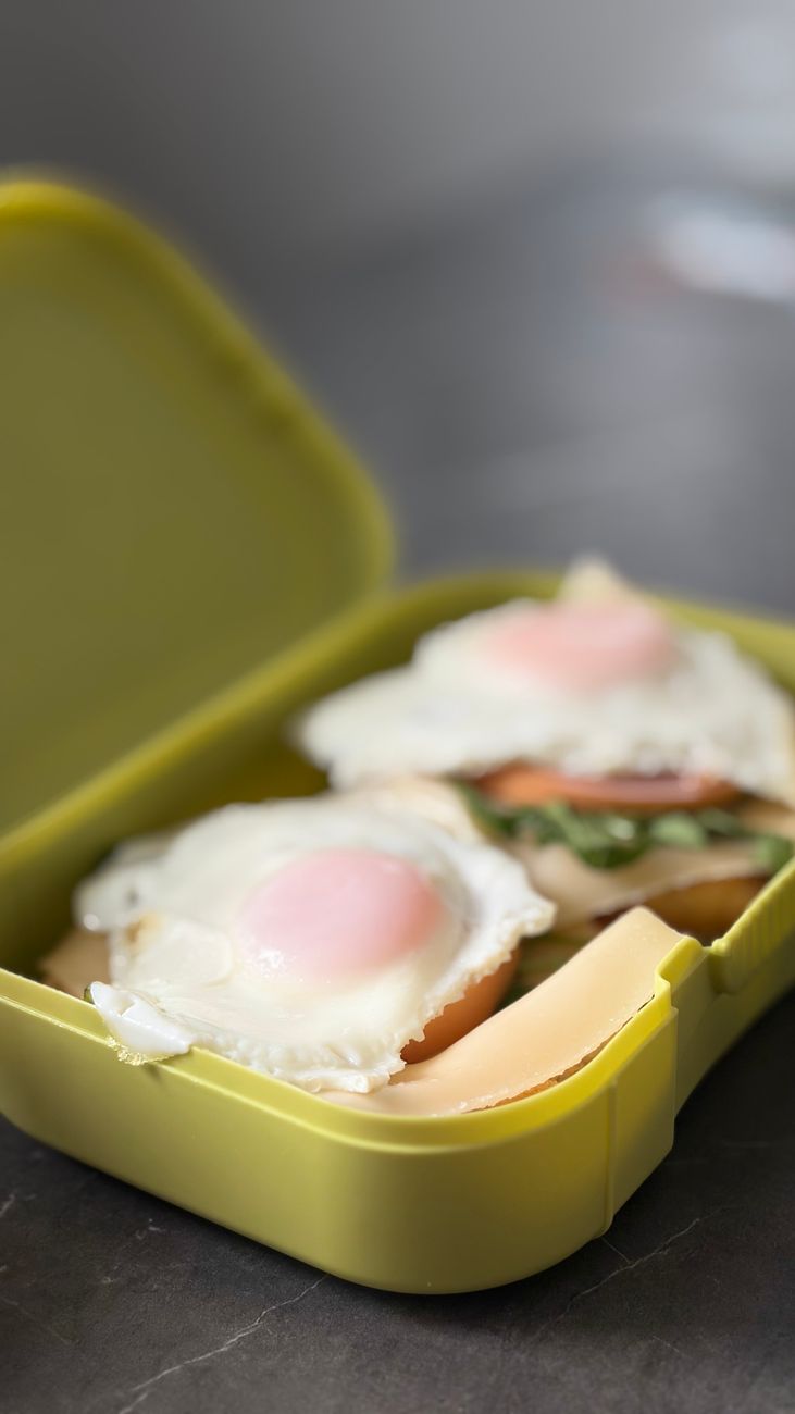 Breakfast sandwiches with eggs packed in a bright yellow lunch box