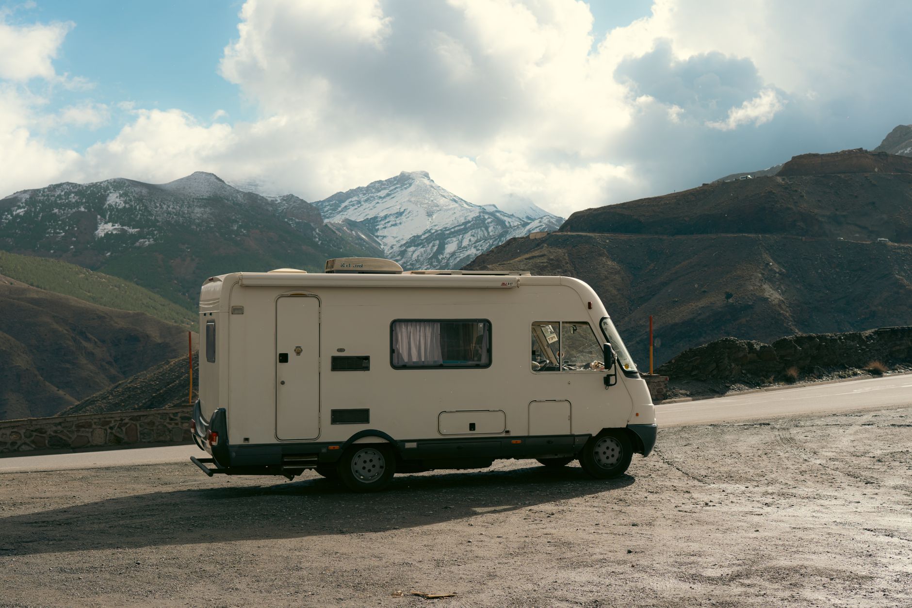 Camper van parked on the roadside with a stunning snowy mountain backdrop