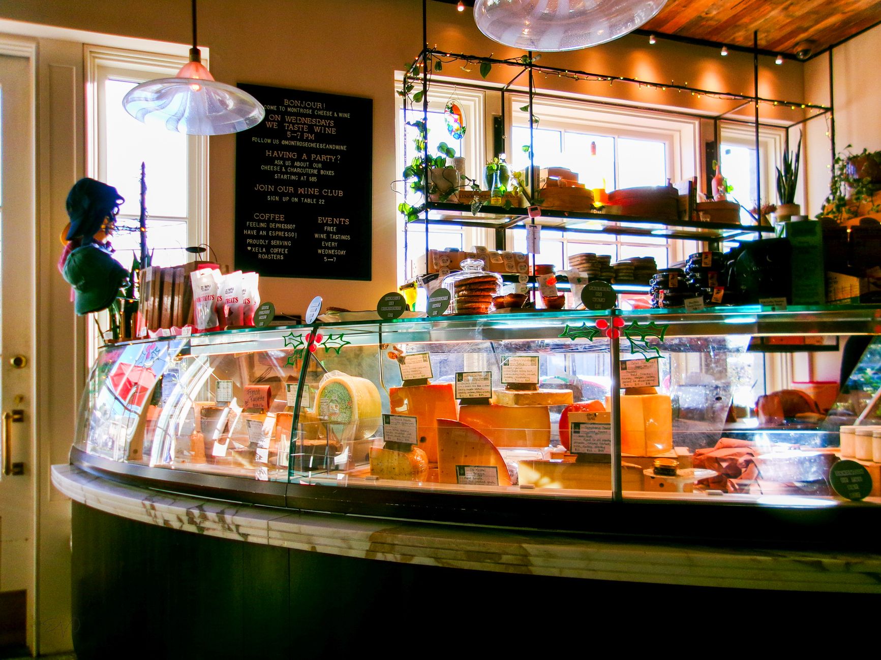 A cozy cheese counter with various cheeses and deli products