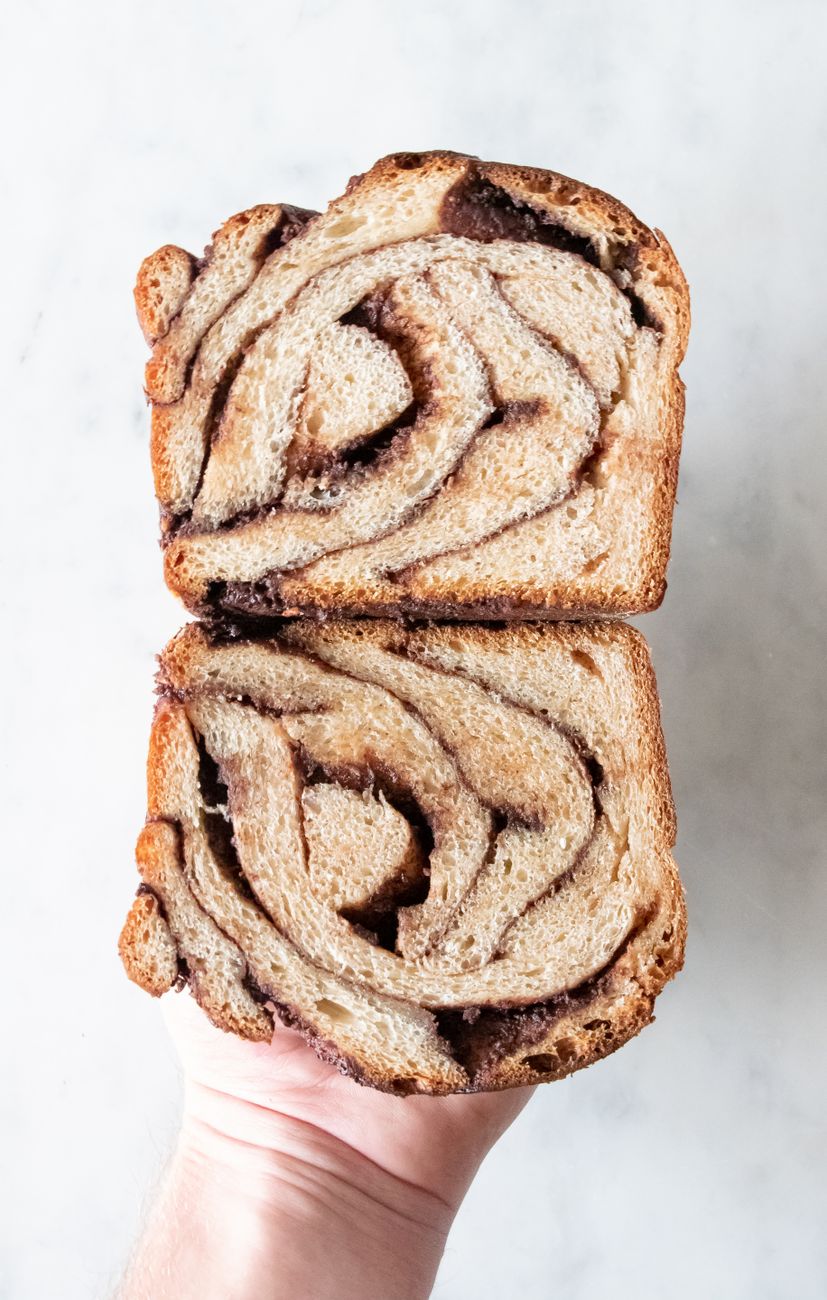 Close-up of a hand holding delicious chocolate babka slices with swirl pattern
