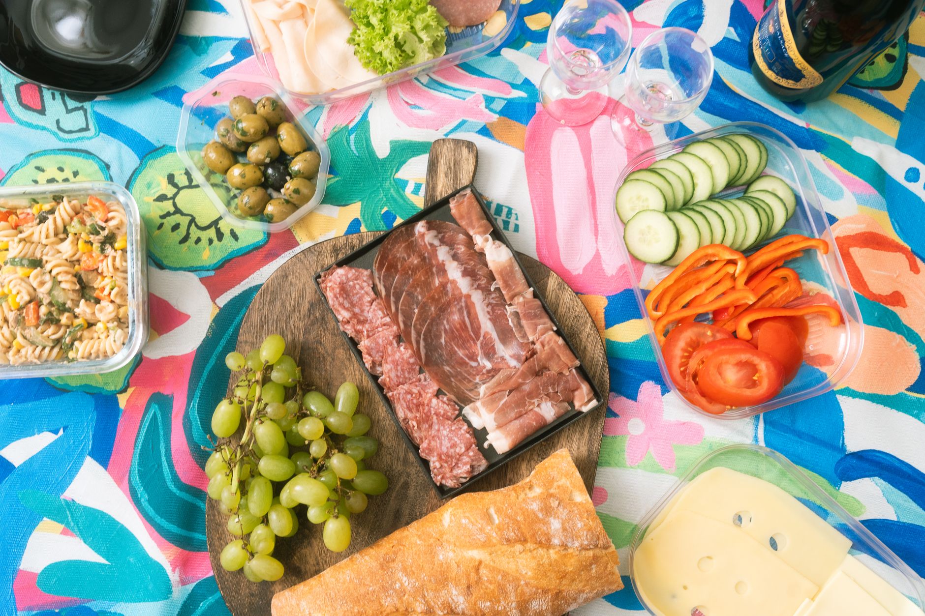 A colorful picnic spread featuring fresh sandwich ingredients