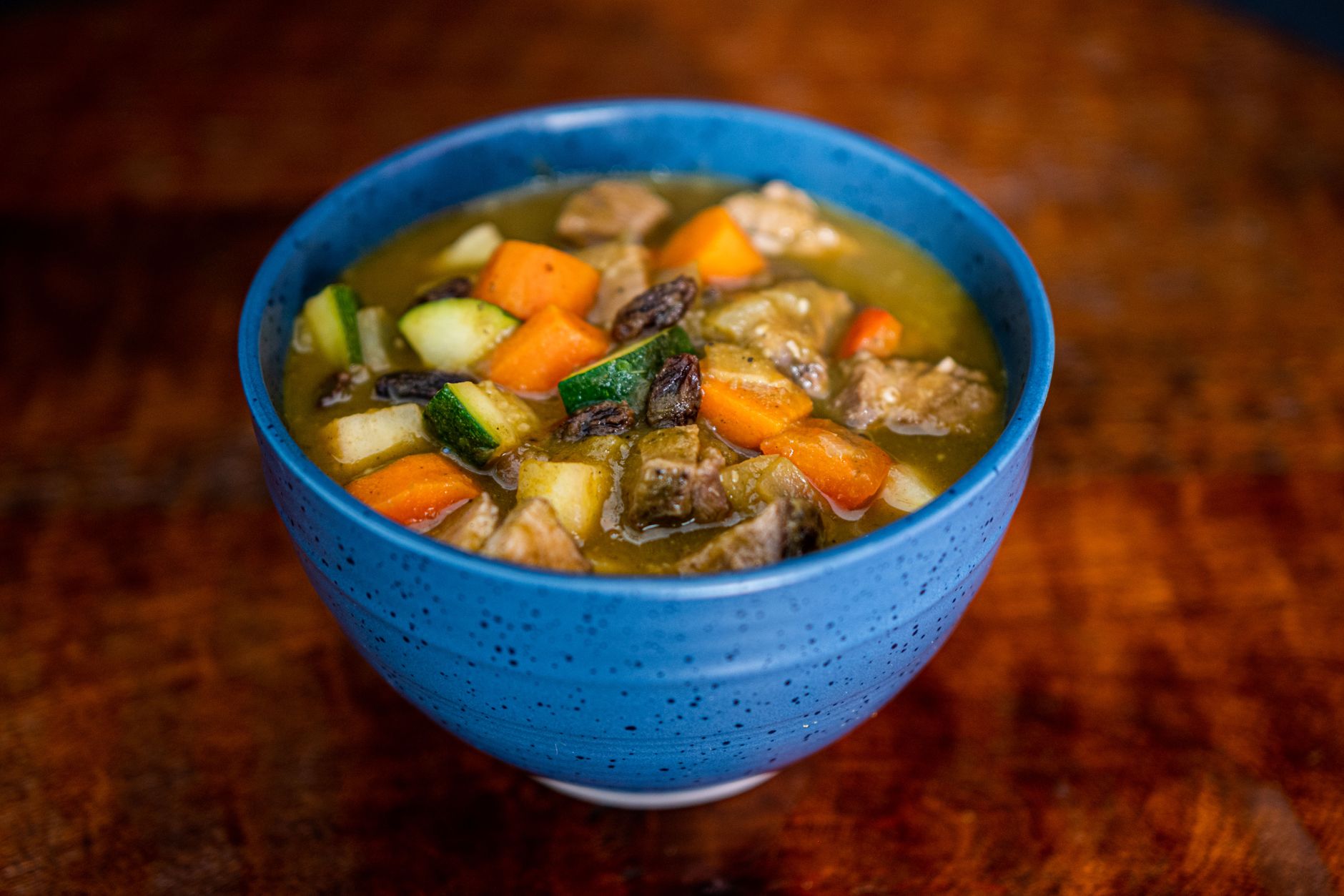 A colorful homemade vegetable stew served in a blue bowl