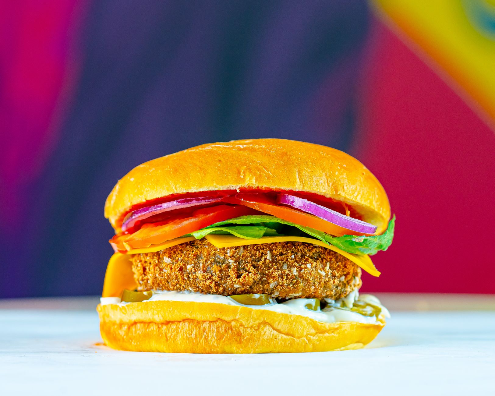 A colorful veggie burger with crispy patty, fresh vegetables