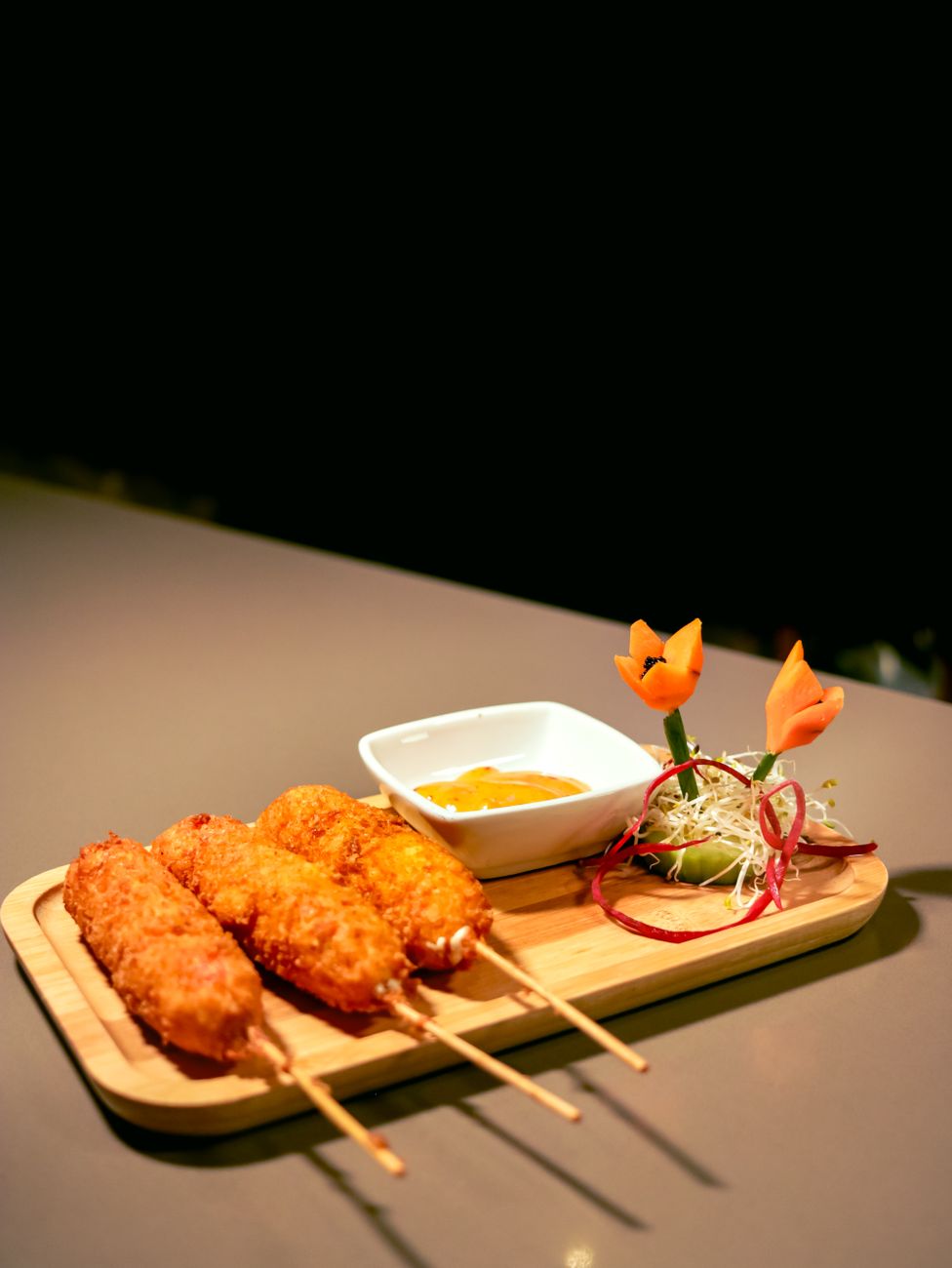 Crispy corn dogs served with dip and garnish on a wooden platter
