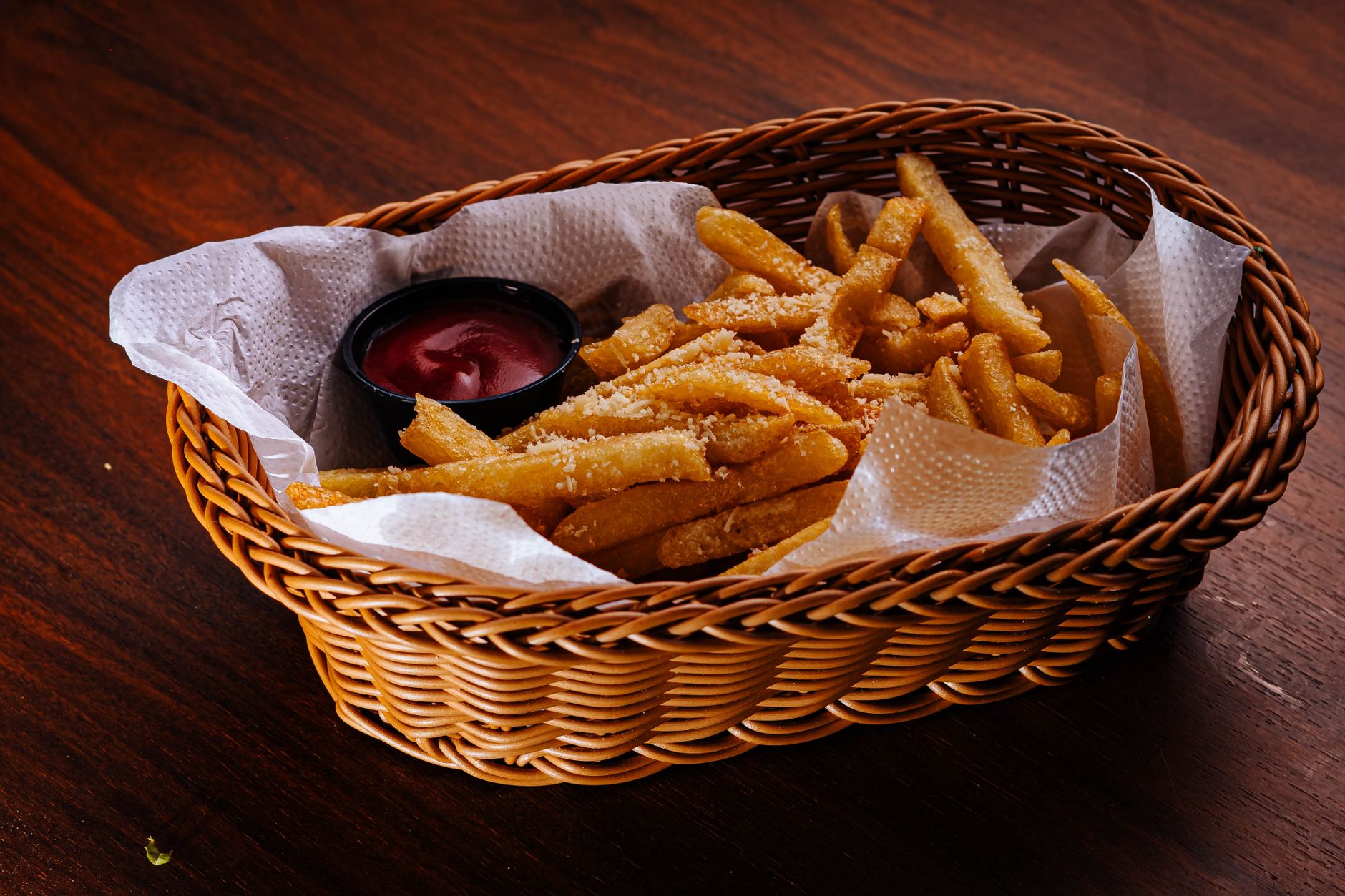 A basket of crispy fries served with a side of ketchup
