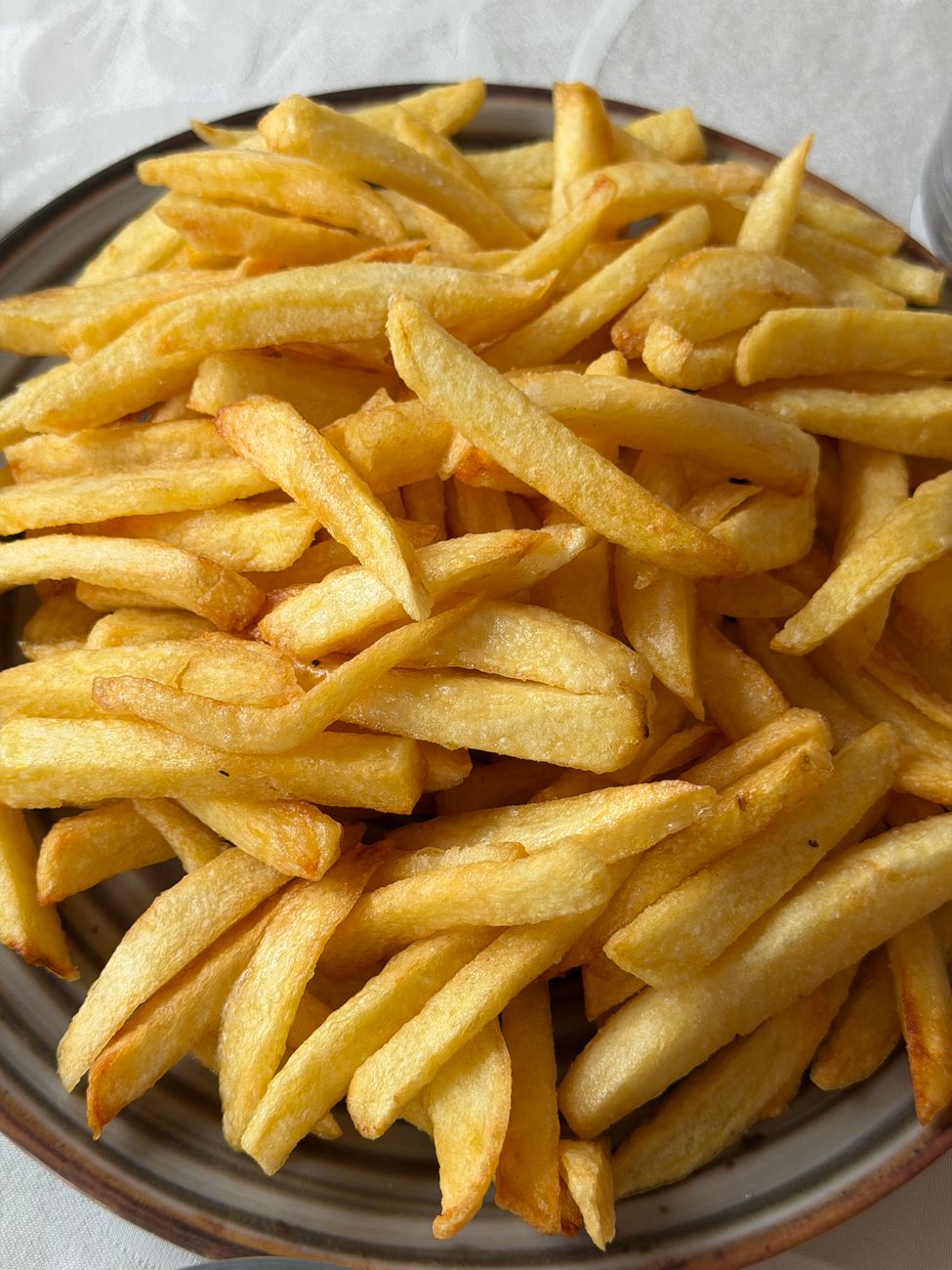 A delectable serving of crispy golden French fries on a ceramic plate