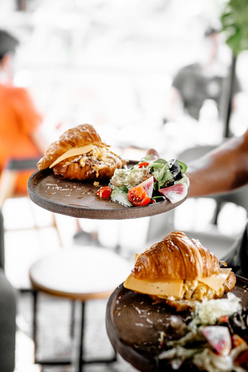Appetizing croissant sandwiches served with fresh salad