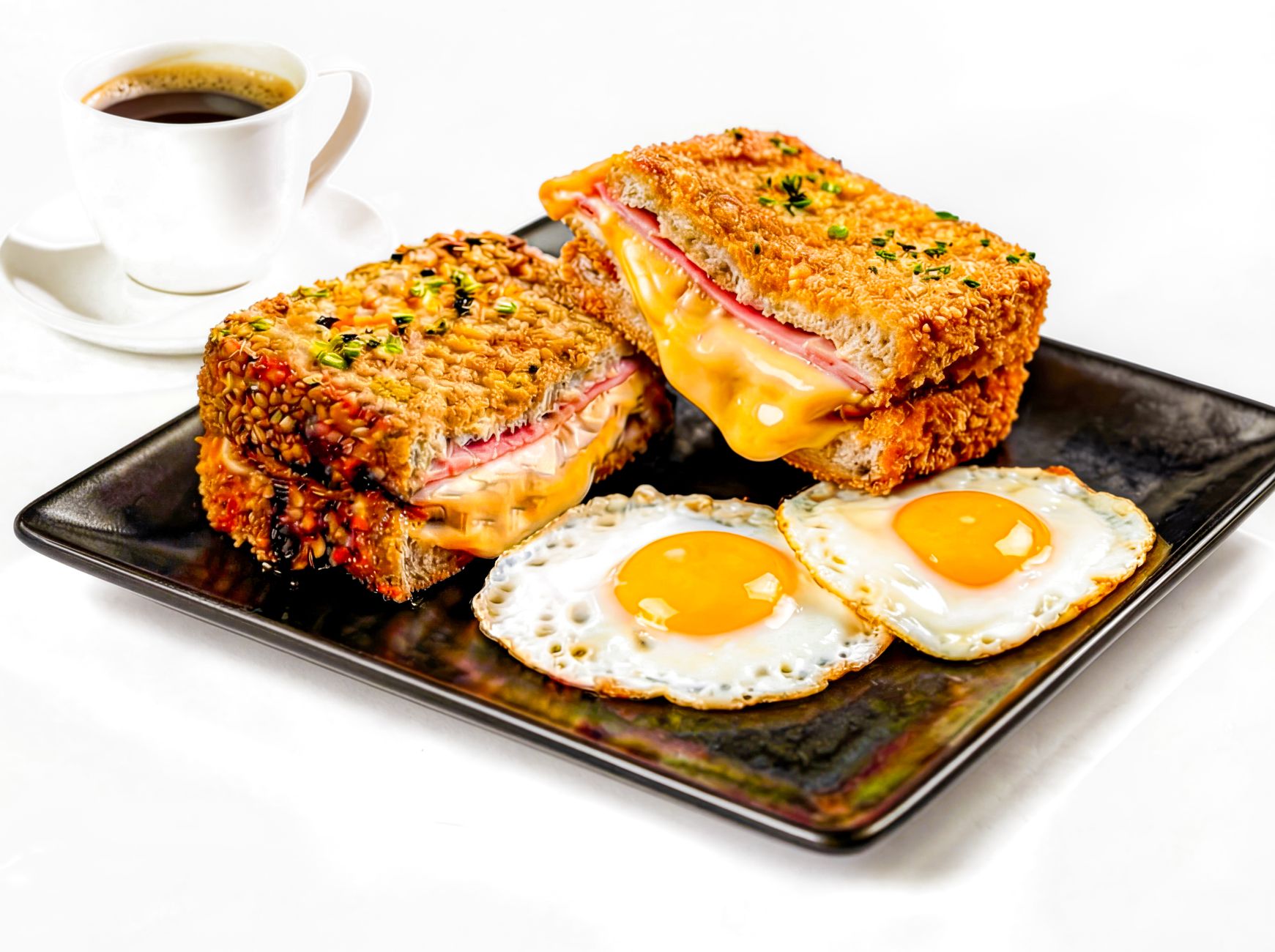A delicious croque monsieur sandwich served with eggs for breakfast
