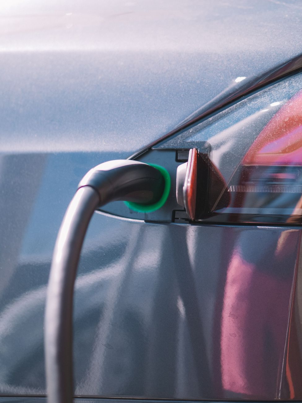 Close-up of an electric vehicle plugged into a charging connector