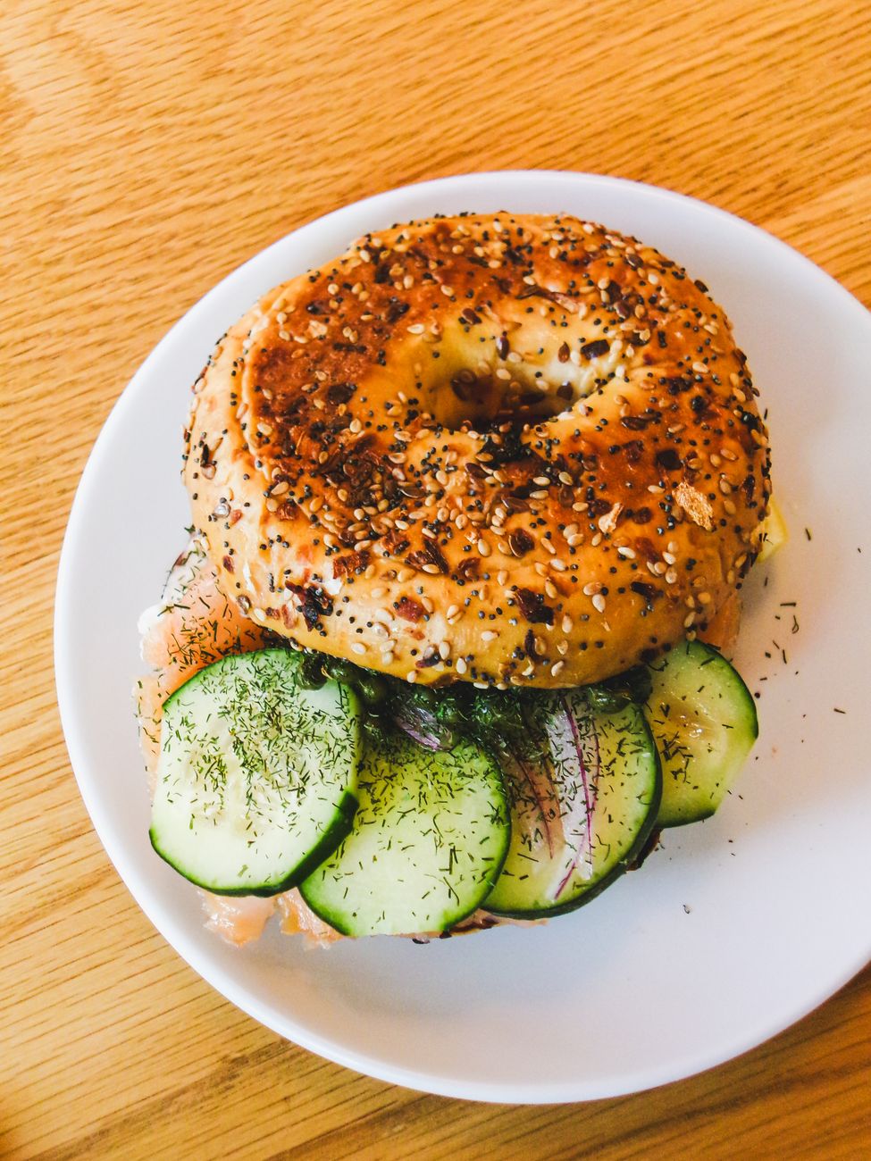 A delicious everything bagel topped with salmon and cucumber