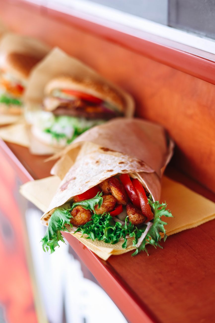 Close-up of a fresh chicken wrap with vegetables on a wooden table