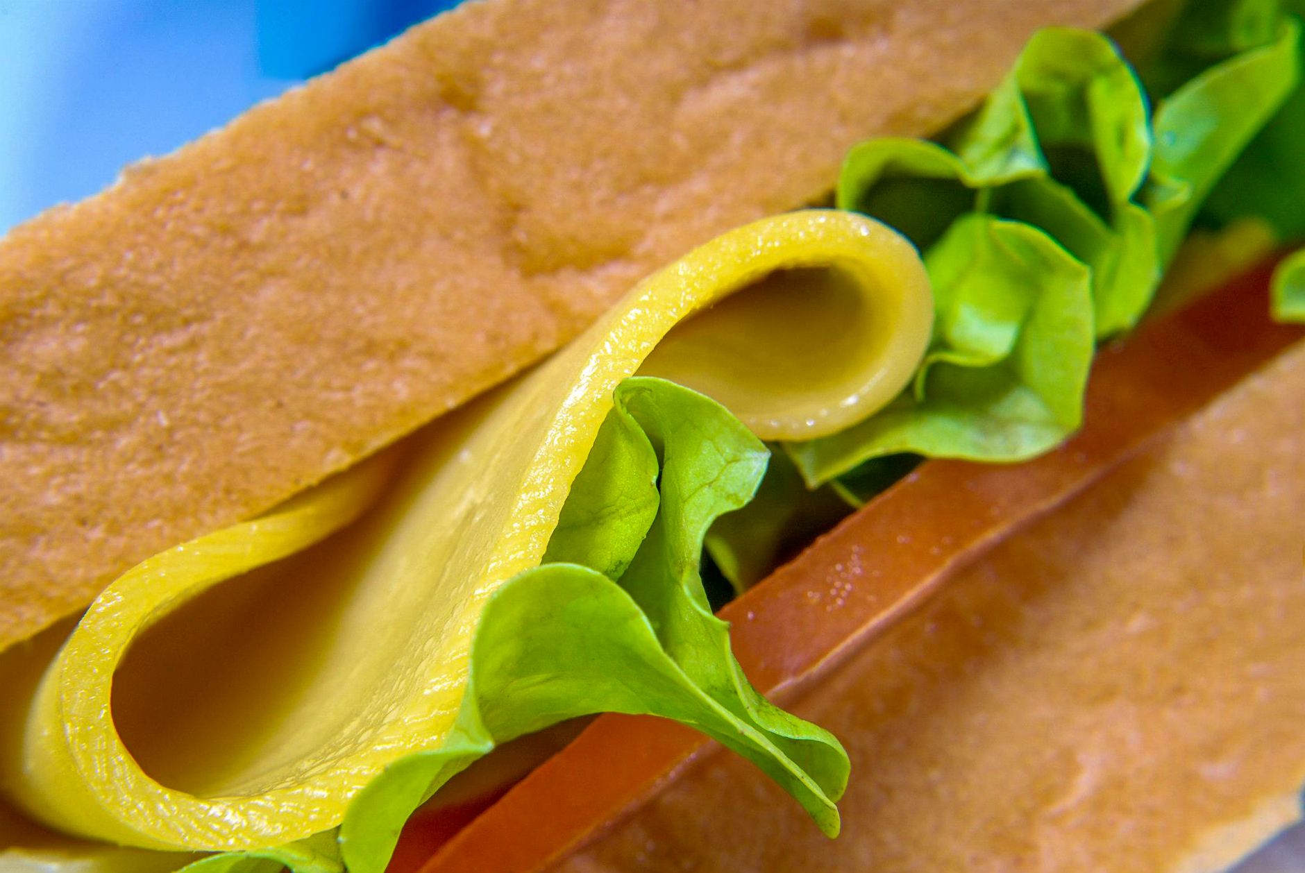 Close-up detail of a fresh deli sandwich layered with lettuce and deli meat