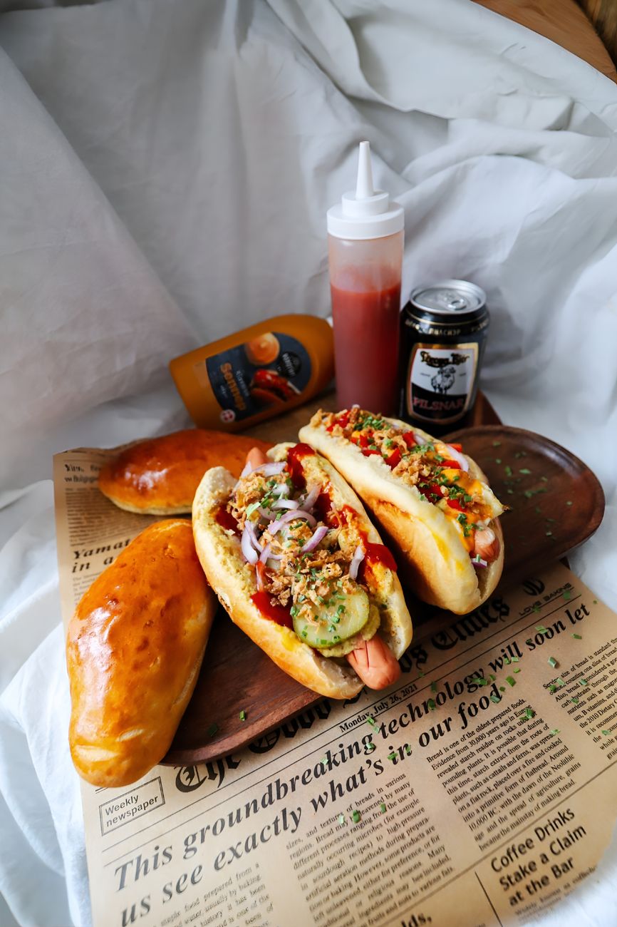 Delicious gourmet hot dogs topped with vegetables and herbs