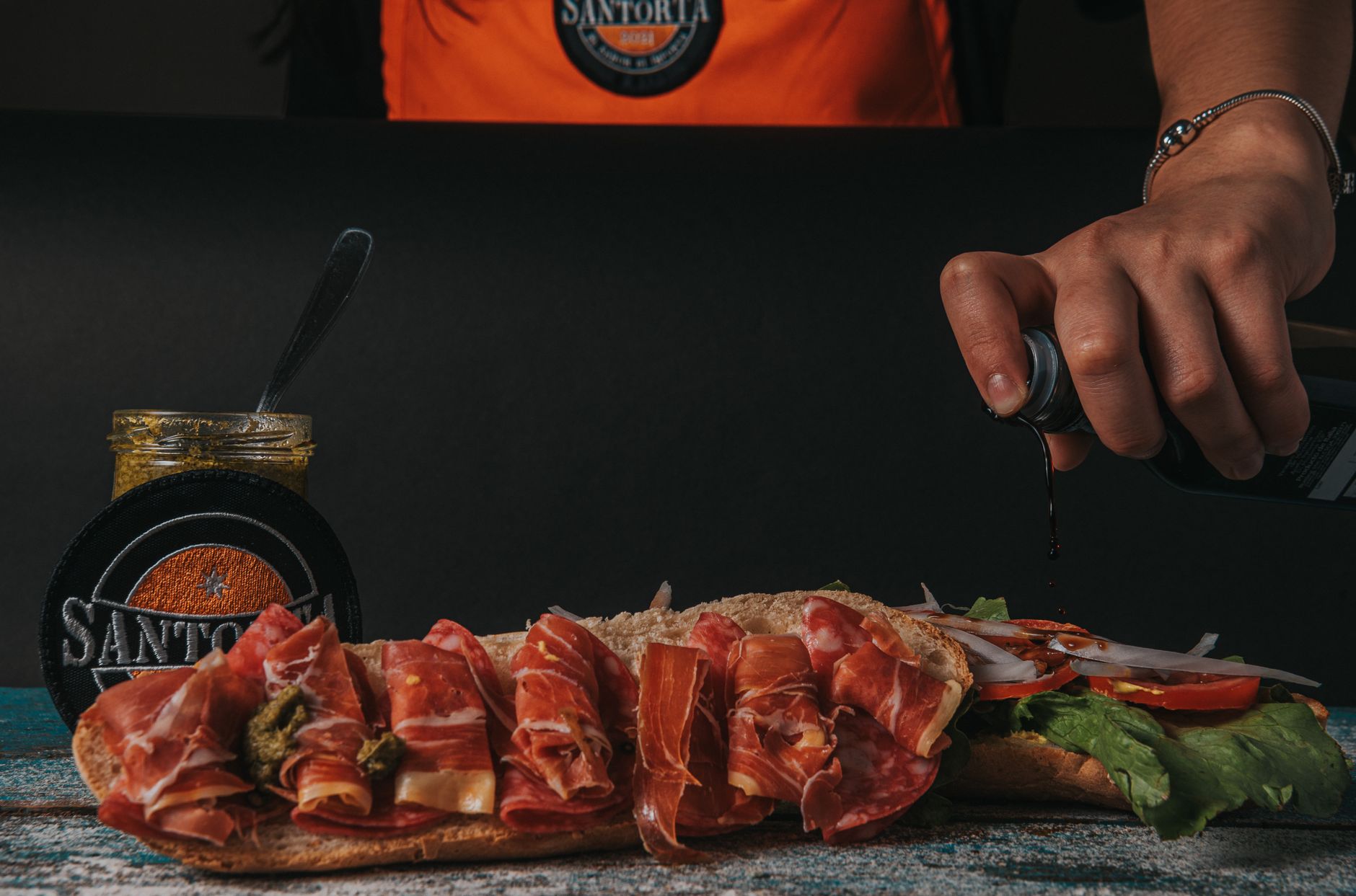 Close-up of a gourmet sandwich being prepared with fresh ingredients
