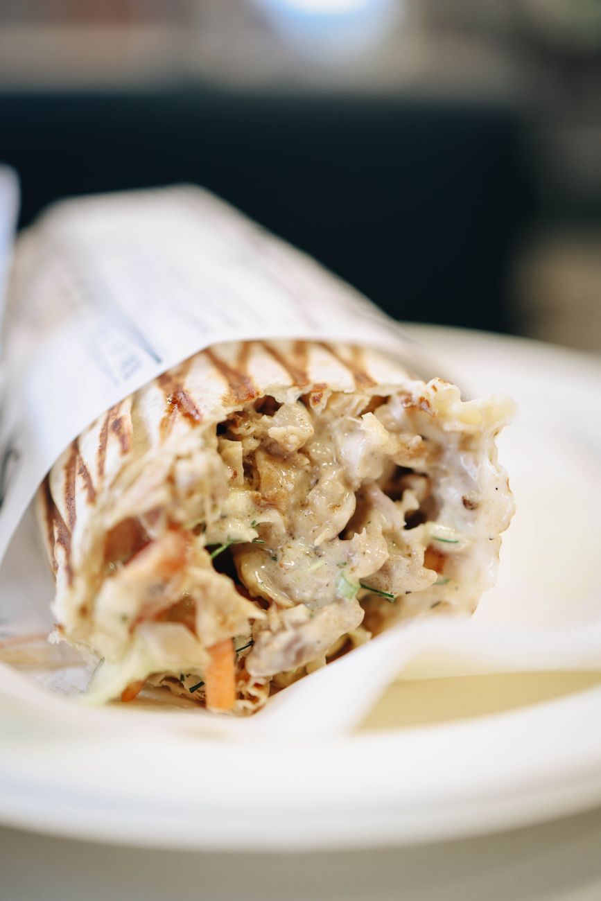 Close-up of a delicious grilled chicken shawarma wrap on a plate