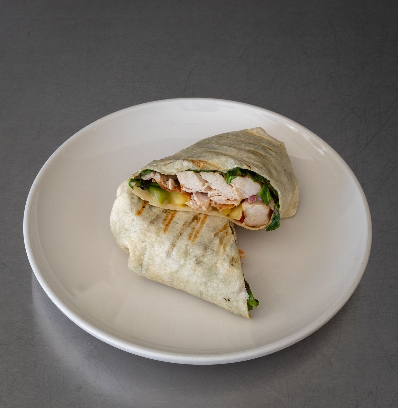 Close-up of a tasty grilled chicken wrap with fresh ingredients