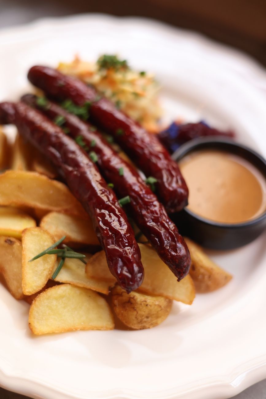 Tantalizing grilled sausages served with crispy potato wedges