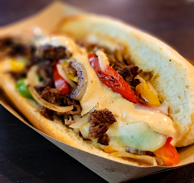 Mabel's Deli handcrafted Philly cheesesteak sandwich with peppers, onions, and cheese