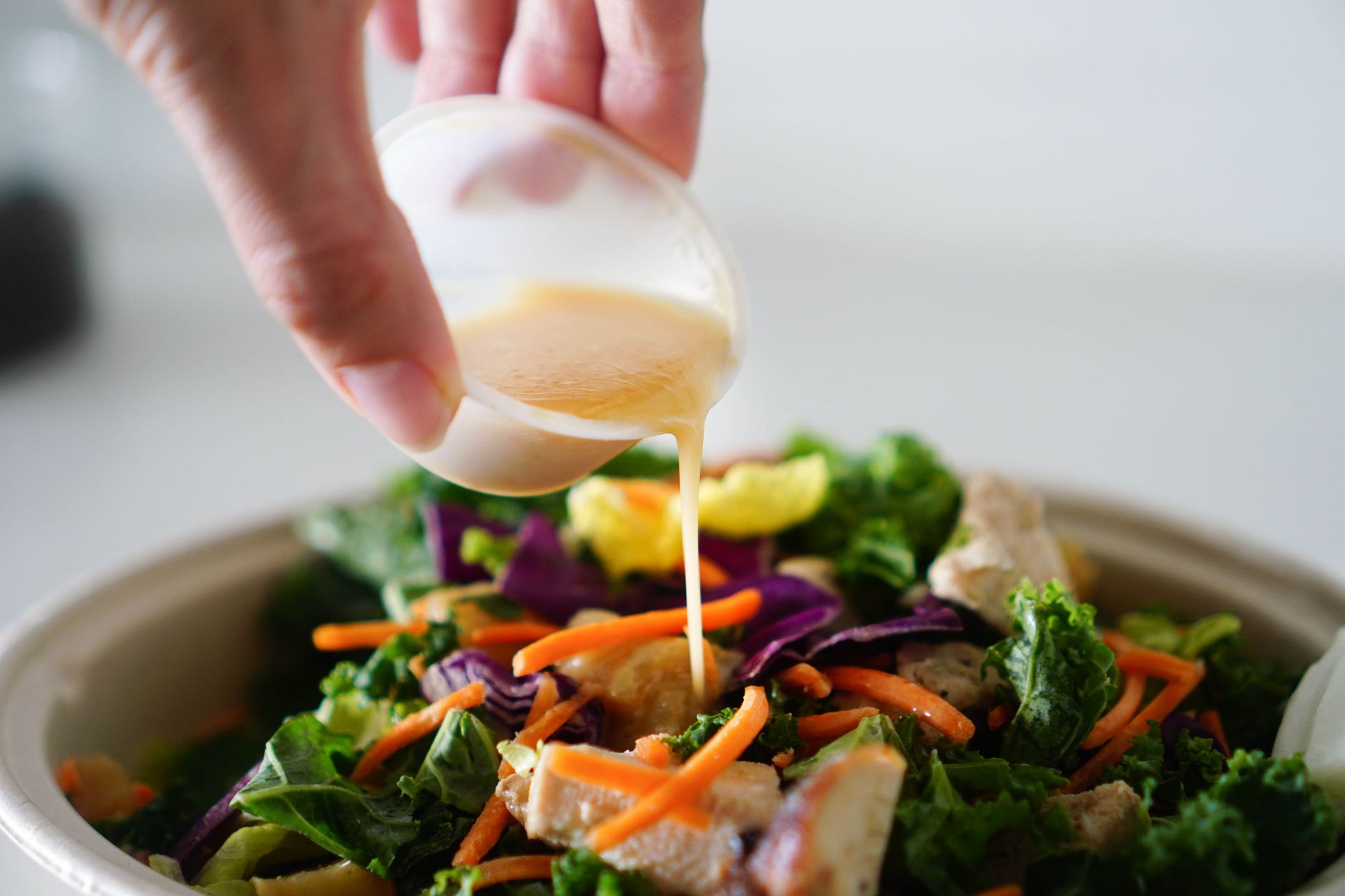 A delicious and healthy salad topped with fresh dressing being poured