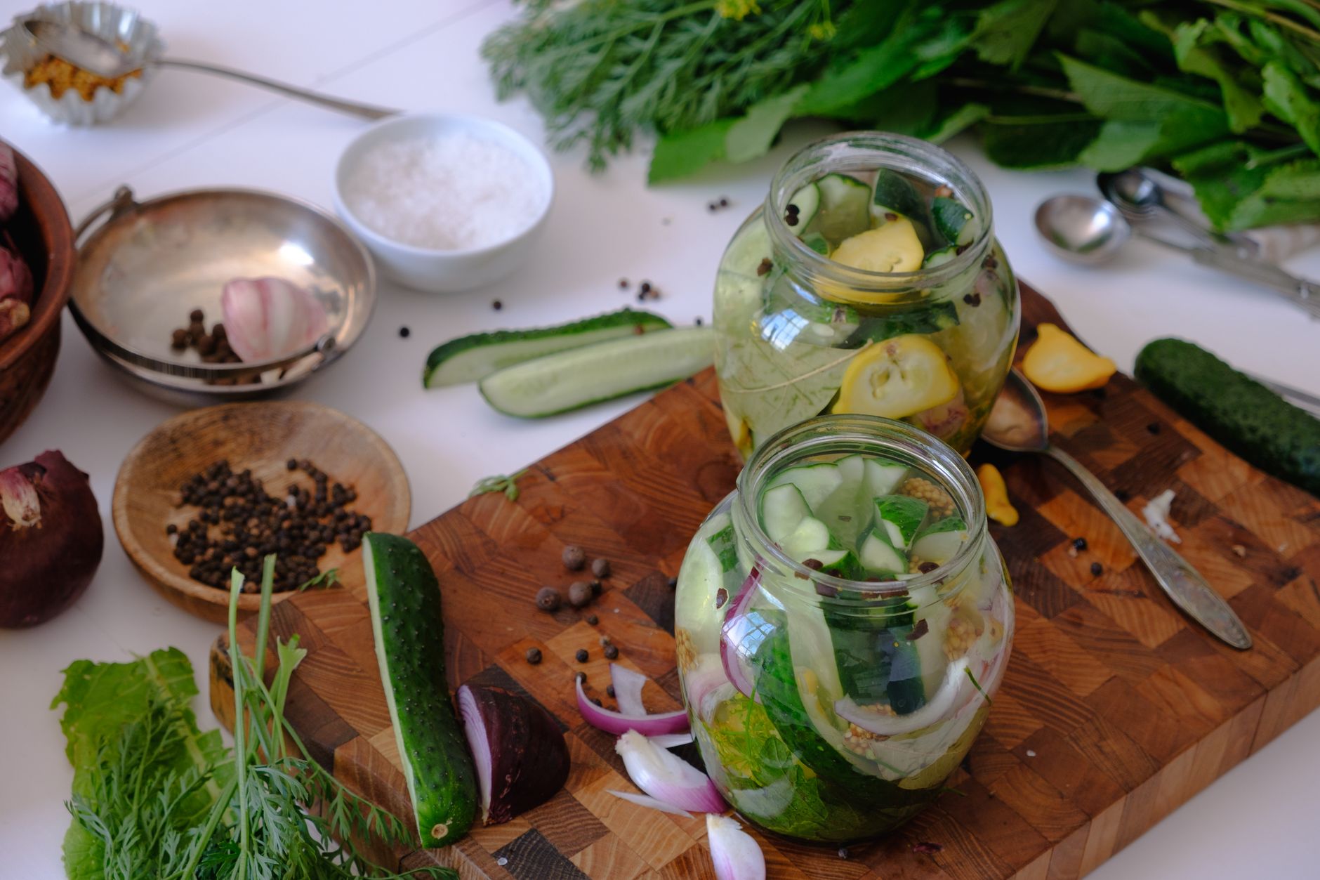 High angle view of glass jars filled with homemade pickles on a wooden surface