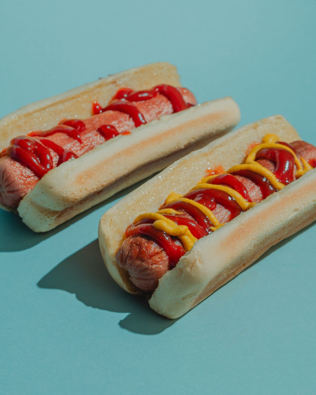 Two delicious hot dogs topped with ketchup and mustard