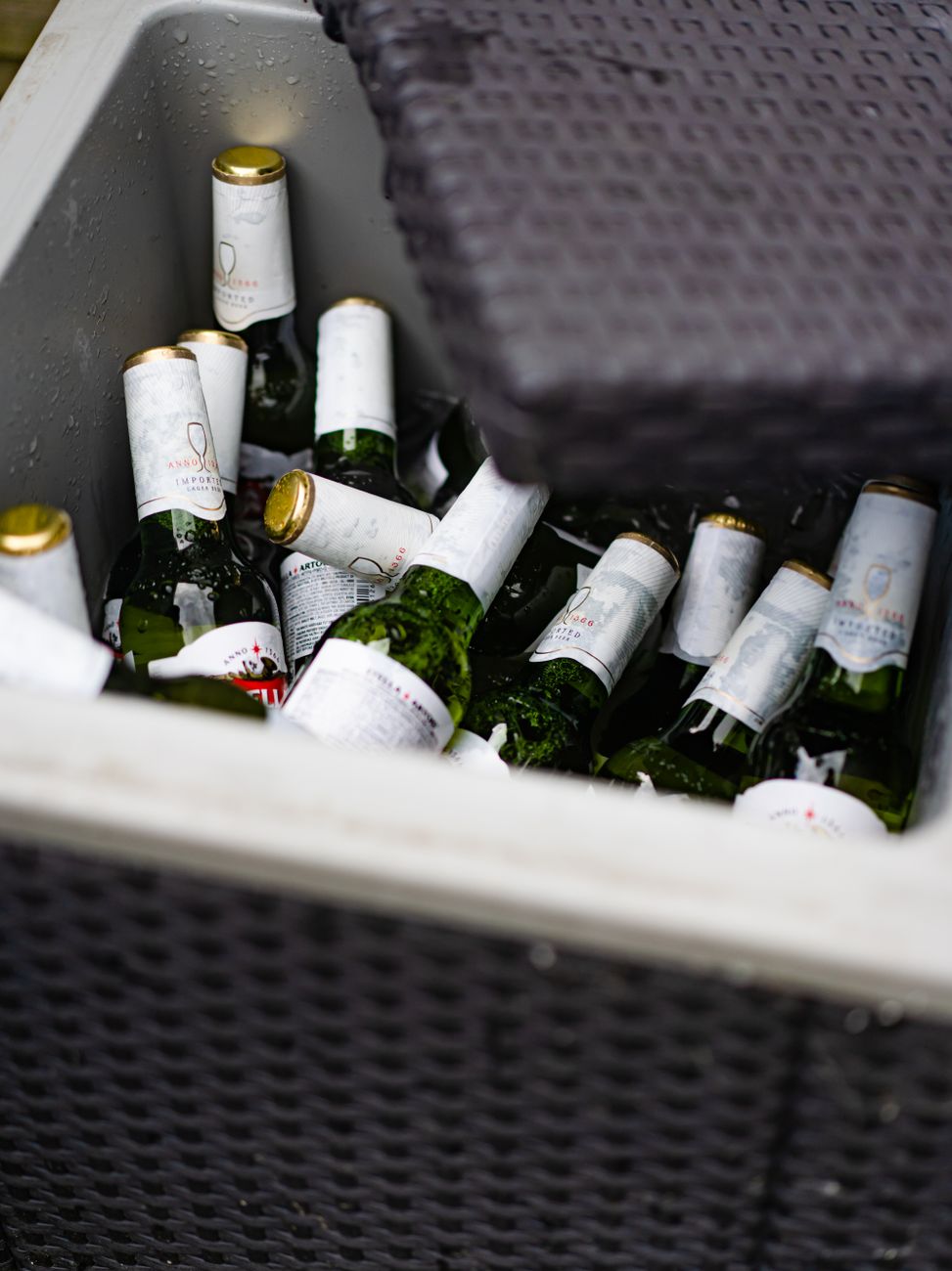 Ice-cold bottles stored in a wicker cooler, perfect for summer gatherings