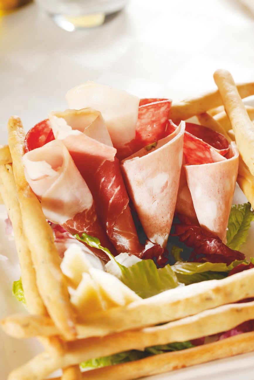 Close-up of Italian prosciutto and breadsticks on a plate
