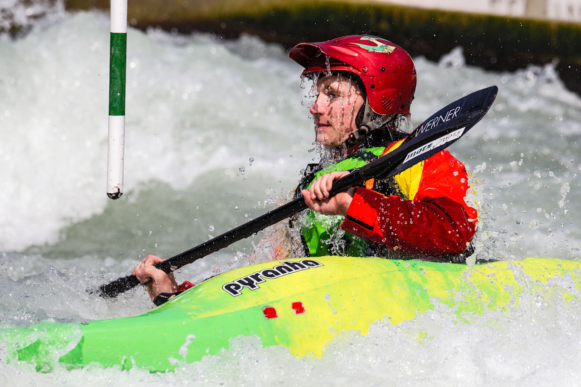Dynamic action shot of a kayaker navigating rapids in a vibrant kayak