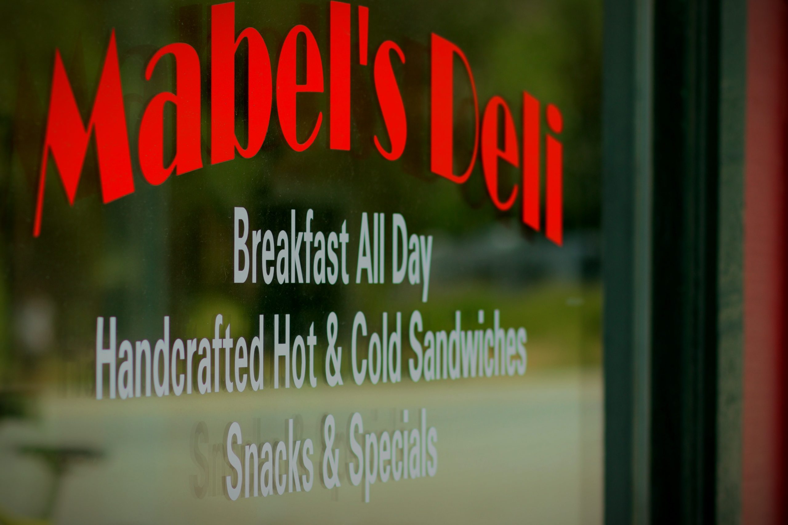 Mabel's Deli window decal reading Breakfast All Day, Handcrafted Hot and Cold Sandwiches, Snacks and Specials
