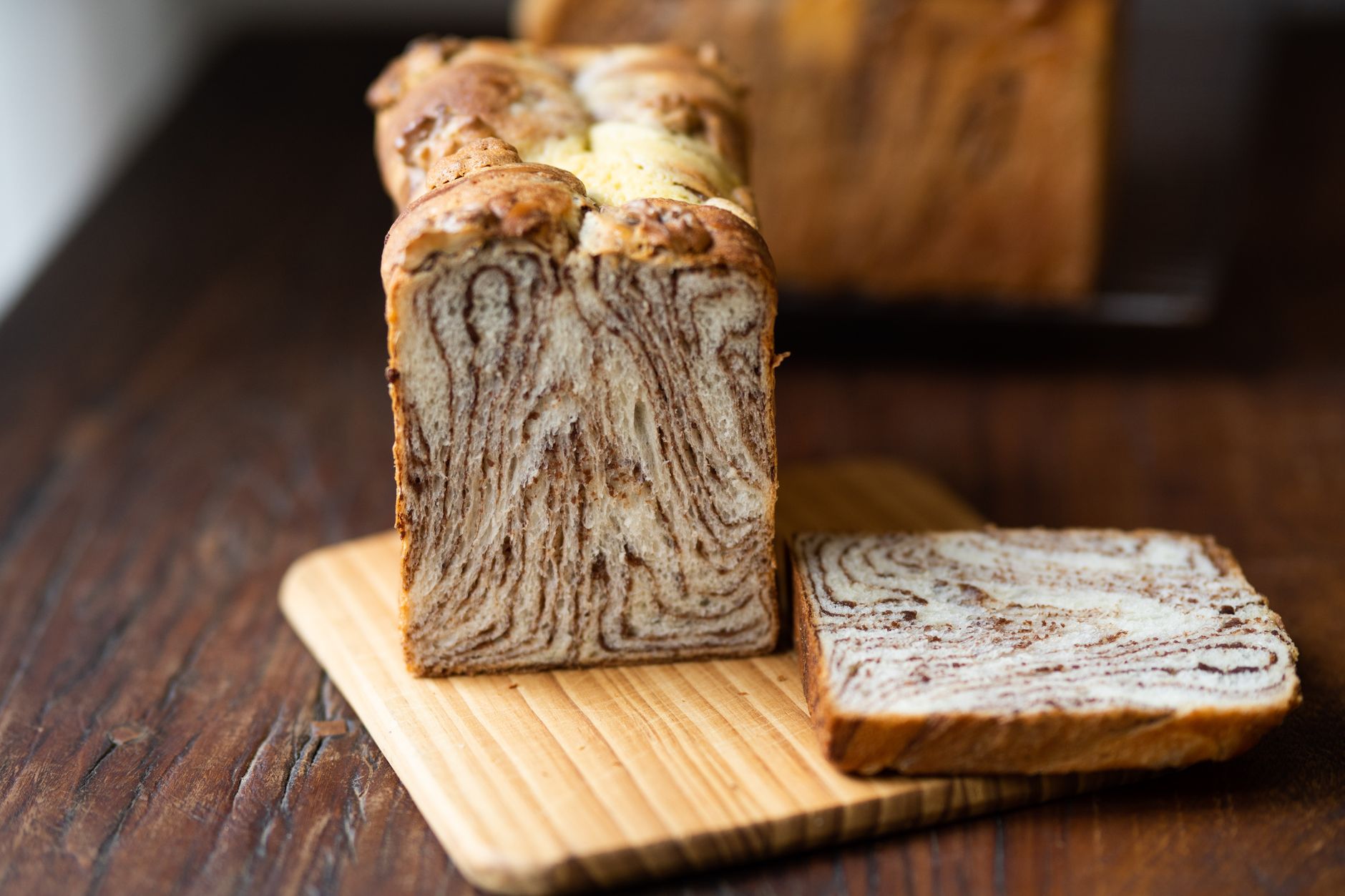 Close-up view of a freshly baked marble bread loaf sliced on a wooden board