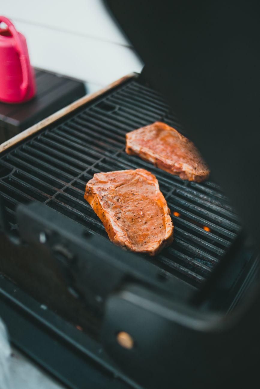 Mouth-watering marinated steaks sizzling on a barbecue grill outdoors