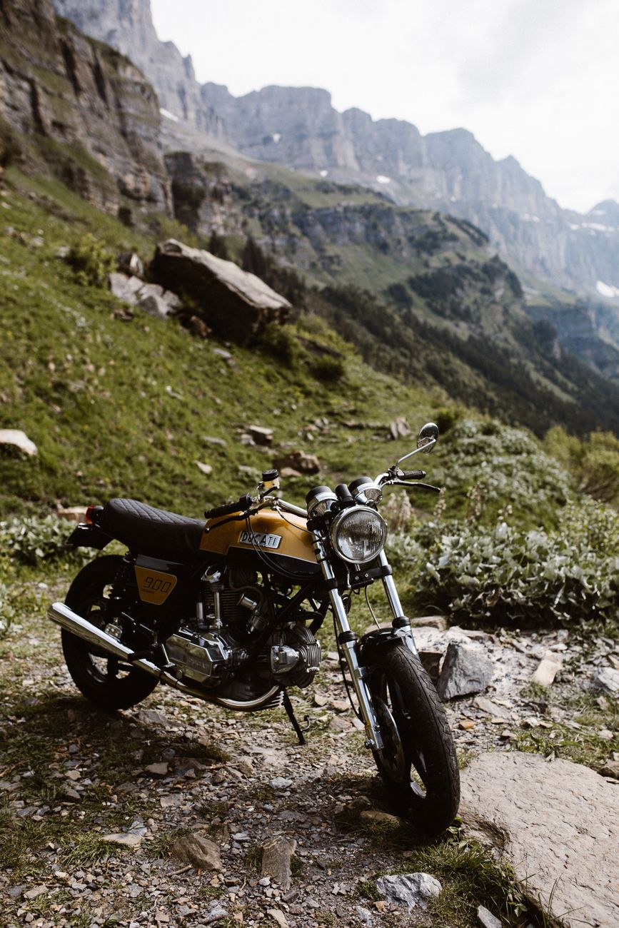 A motorcycle parked in a picturesque mountain setting