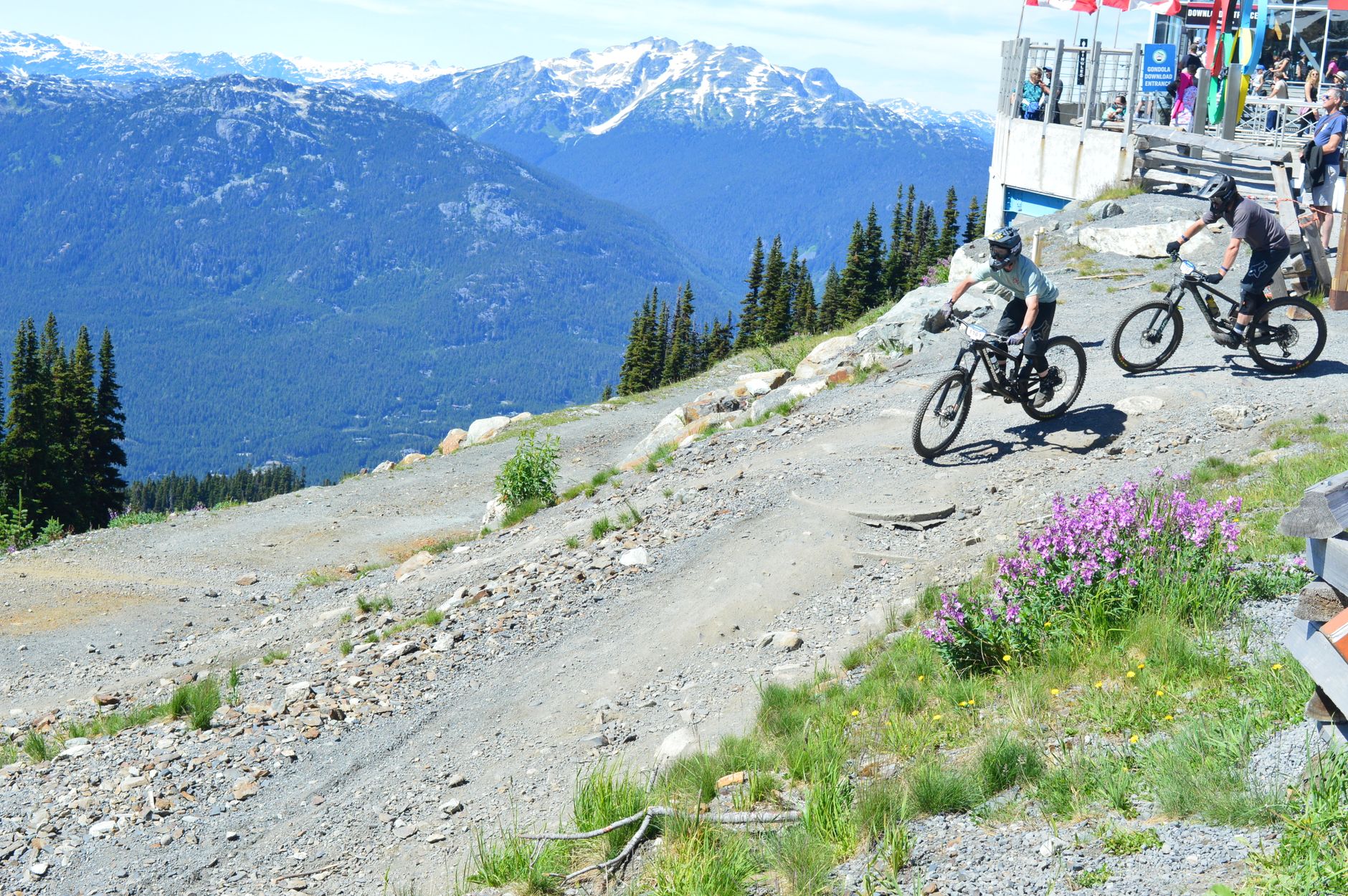 Cyclist riding down a scenic mountain trail with stunning alpine views