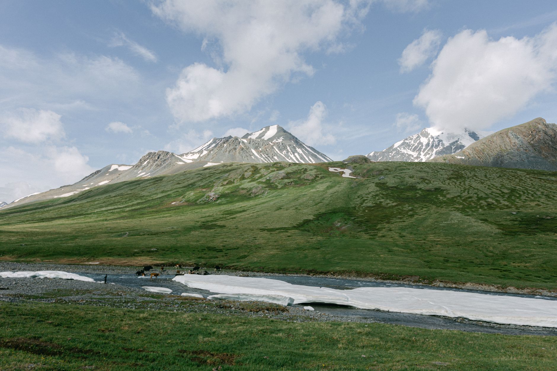 Picturesque mountain range with snow-capped peaks and lush green valleys