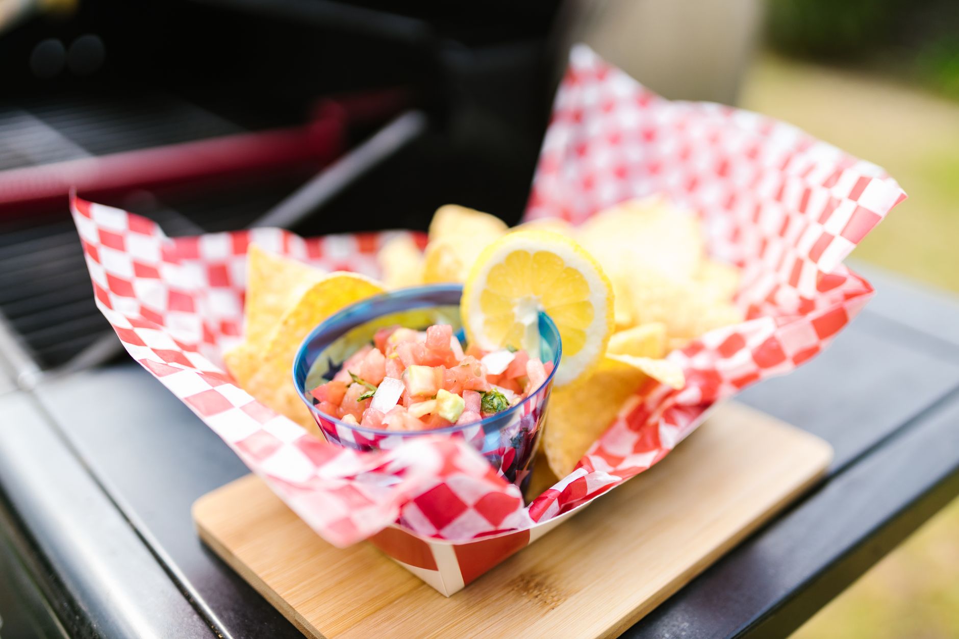 Close-up of nachos with fresh salsa and lemon