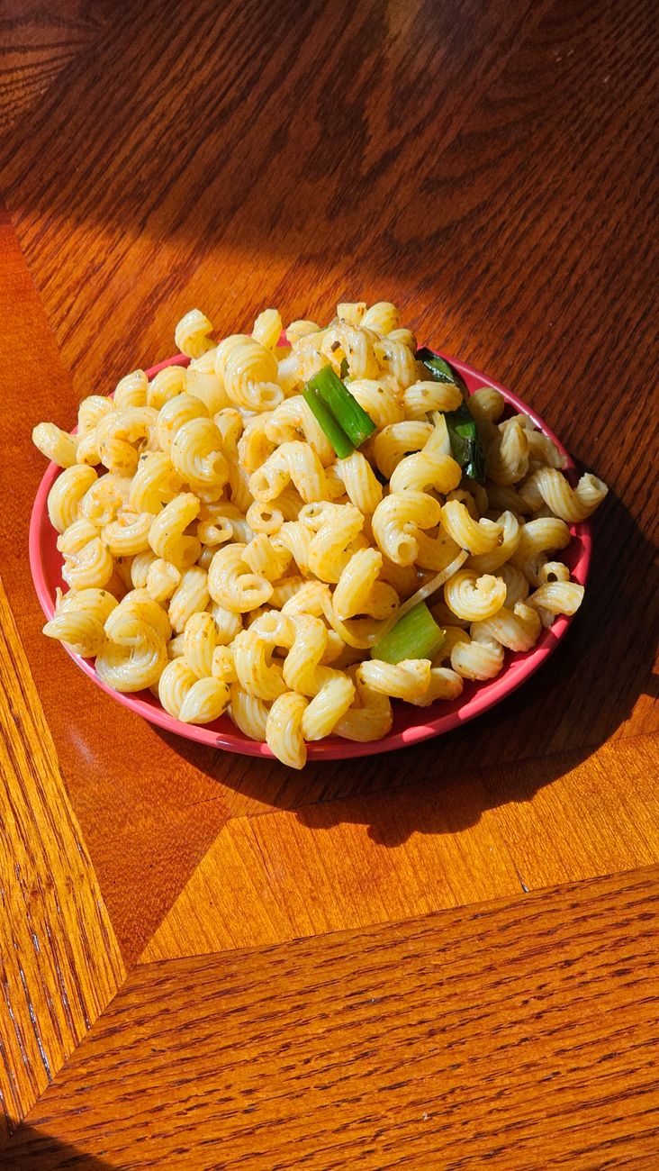 A dish of pasta ready to eat, served on a wooden table