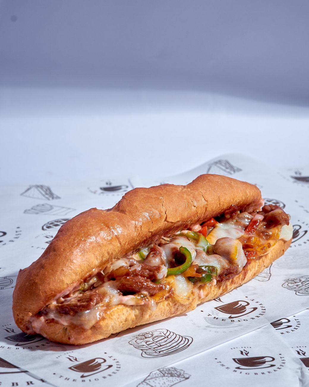 Close-up of a Philly cheesesteak sandwich with melted cheese and grilled peppers