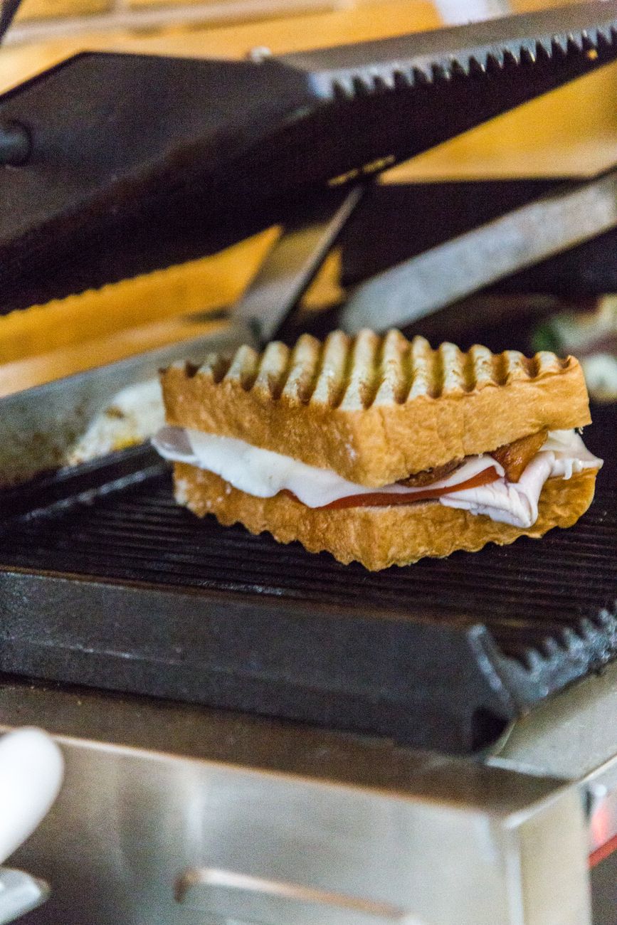 A pressed sandwich cooking on a hot electric griddle