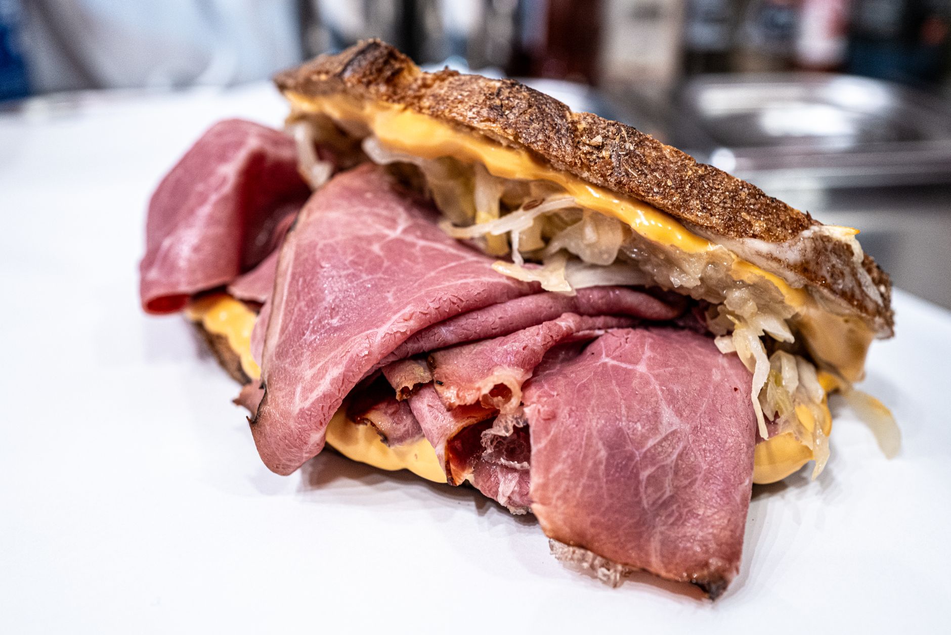 Close-up of a hot sandwich with melted cheese and sauerkraut on rye