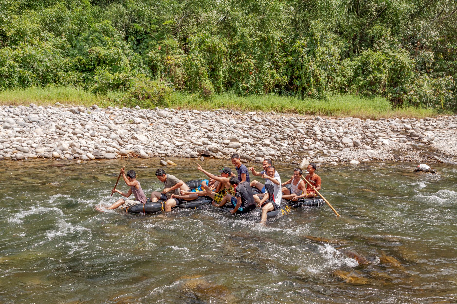 Group of people enjoying a thrilling river rafting experience on a sunny day