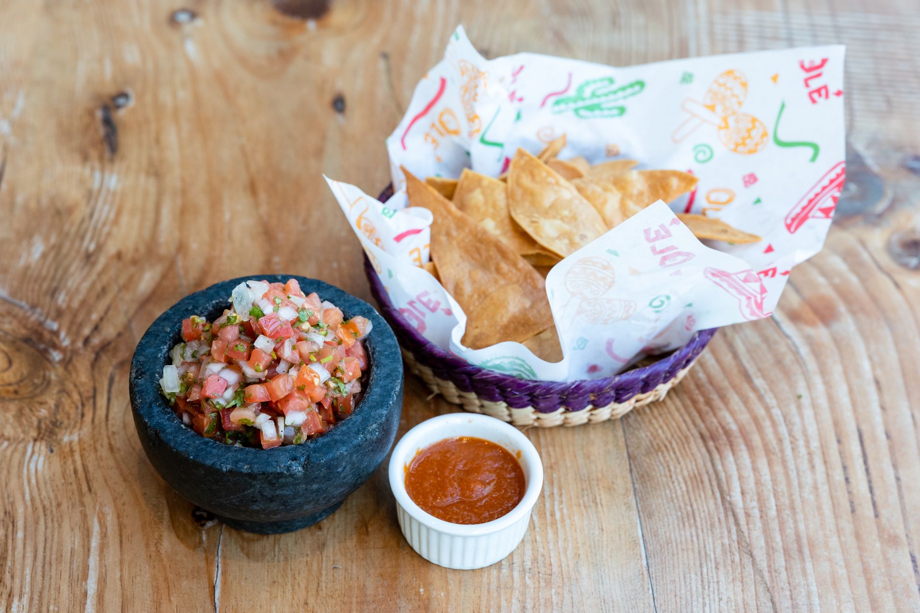 Rustic Mexican salsa and tortilla chips served on a wooden table