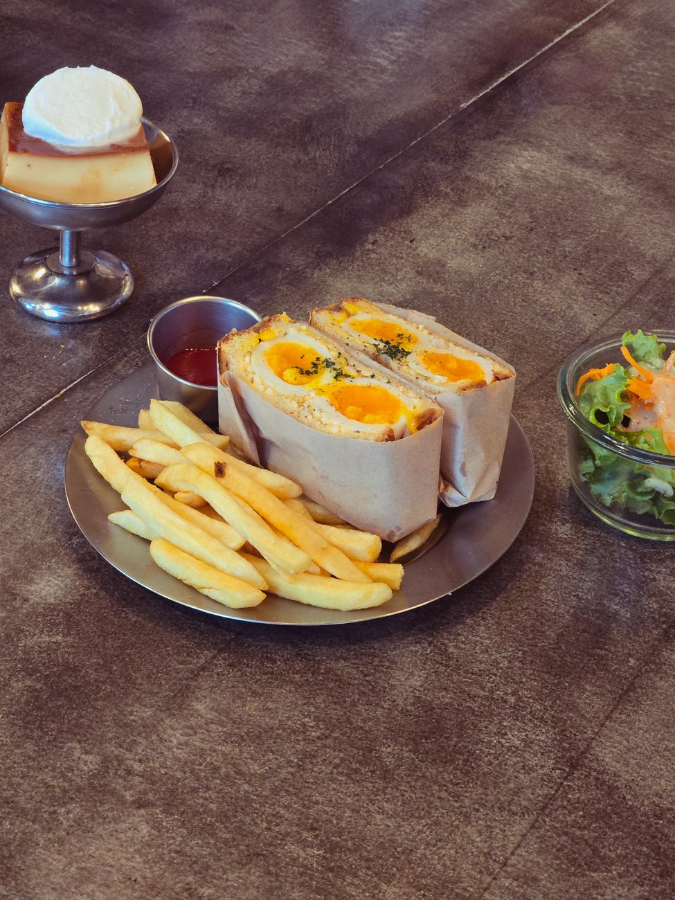 A delicious sandwich meal served with fries and a side dessert