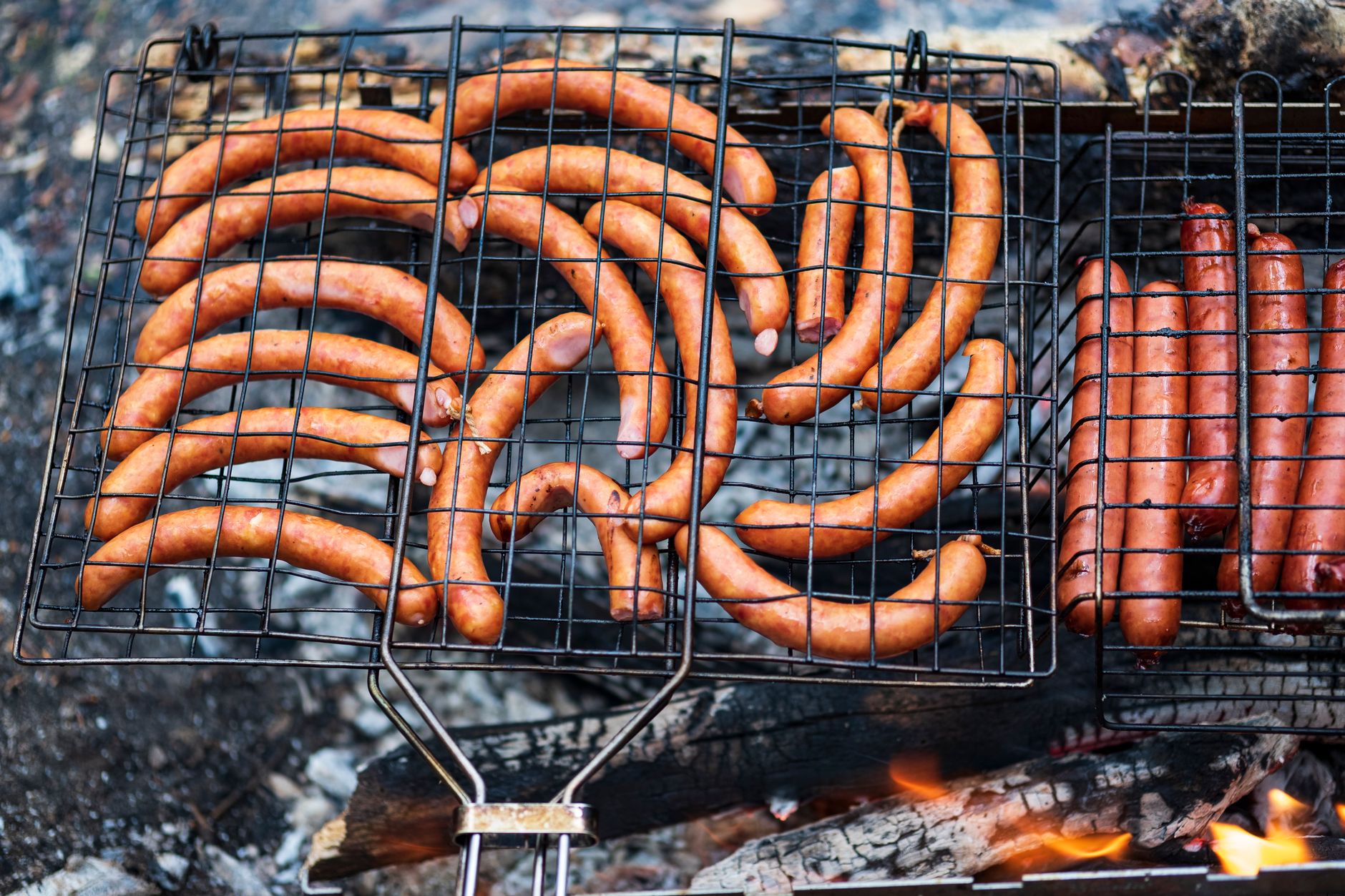 Delicious array of sausages grilling over charcoal flames